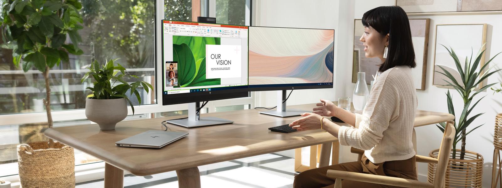 Woman working on a multiple monitor desktop setup