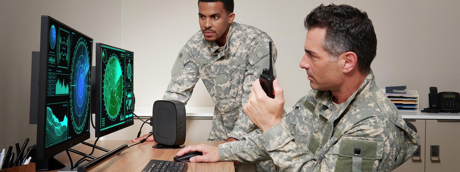Two military employees at double-screen computer